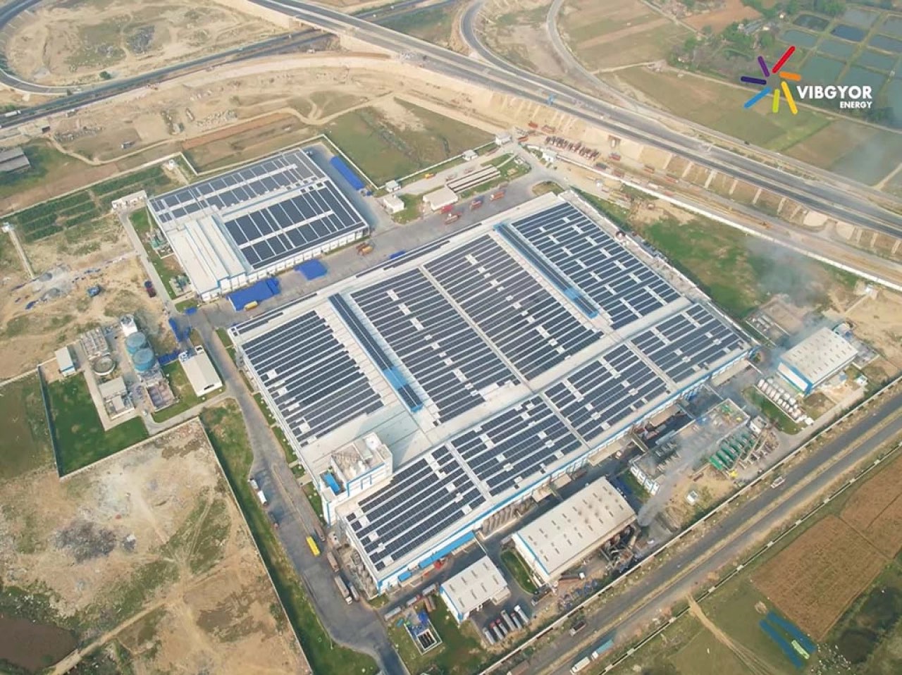 Aerial view of a Vibgyor Energy solar installation across industrial rooftops