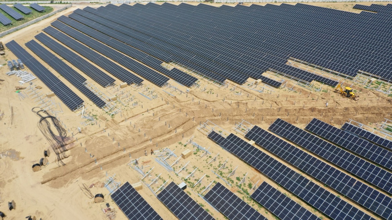 Rows of ground-mounted solar modules under construction at the Chamu park