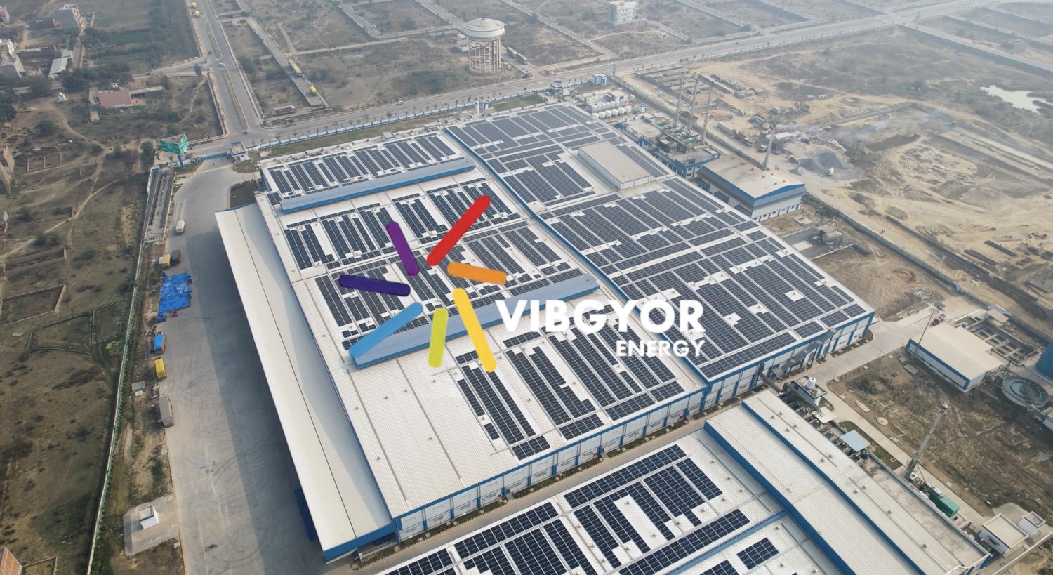 Aerial view of a large multi-hall industrial rooftop solar installation